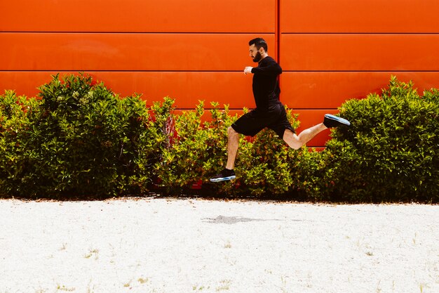 Atleta maschio sicuro che fa un salto in lungo