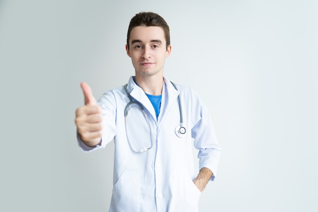 Confident male doctor showing thumb up