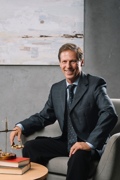 Free photo confident male mature lawyer sitting in office