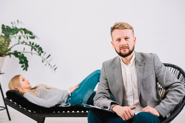 confident male psychologist sitting on chair in front of her female patient