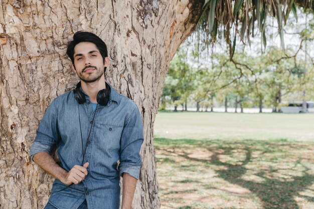 Confident man in earphones posing at camera