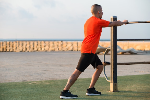 Confident man exercising on playground in morning