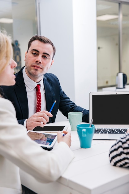 Confident man having meeting with coworkers