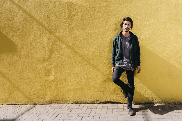 Confident man posing on street in headphones