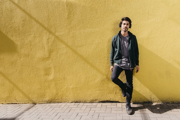 Confident man posing on street in headphones