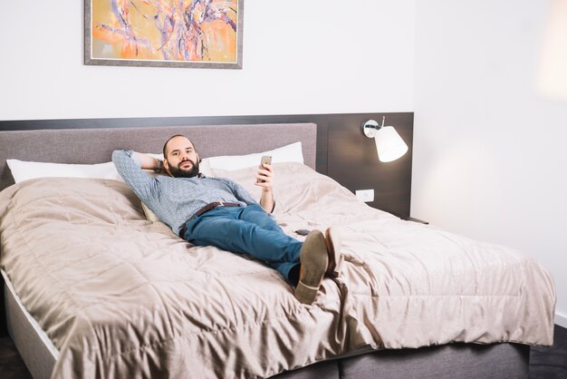 Confident man relaxing on bed