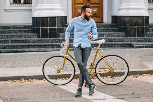 Confident man with bicycle on rodside
