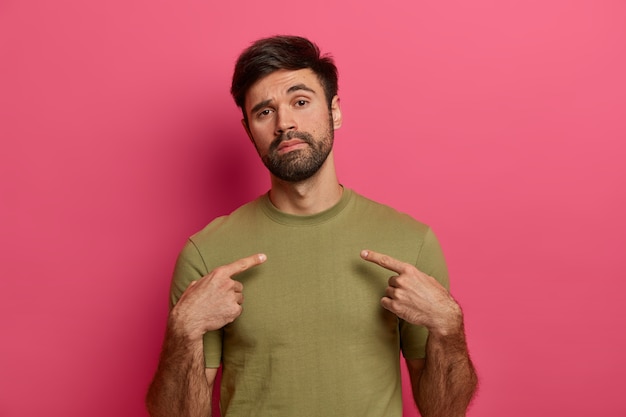 Foto gratuita uomo fiducioso con una folta barba, indica se stesso