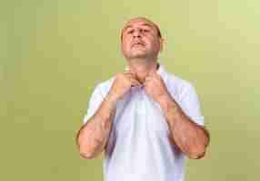 Free photo confident mature man holding collar isolated on olive green wall