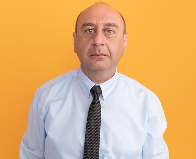 Confident middle-aged man wearing white t-shirt with tie isolated on orange wall
