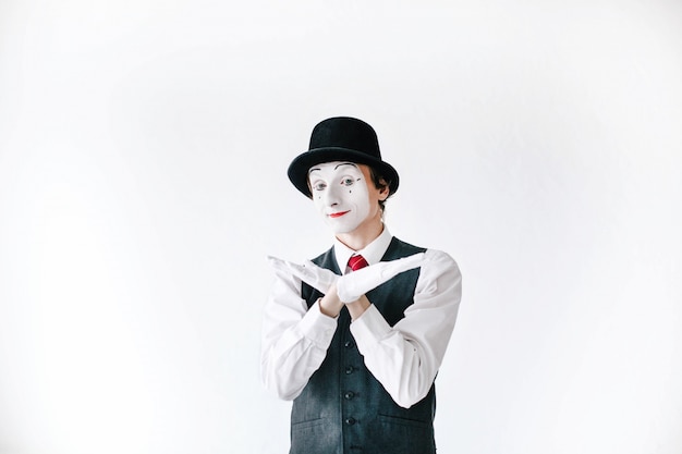 Free photo confident mime in black hat holds his hand slike bird wings