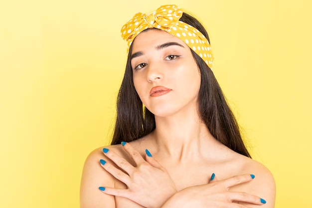 Confident peaceful girl holding her hands to her chest and looking at the camera