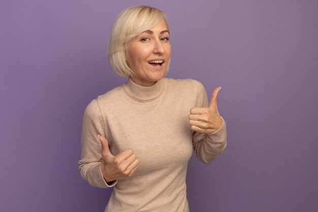 Confident pretty blonde slavic woman thumbs up of two hands on purple