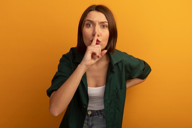 Confident pretty caucasian woman gestures silence