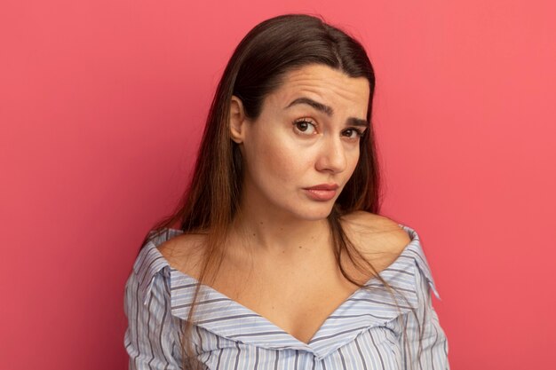 Confident pretty woman looking at front isolated on pink wall