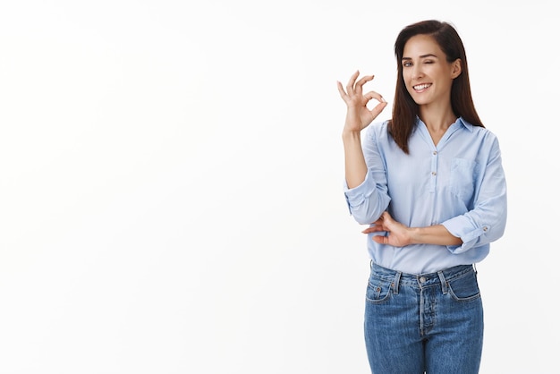 Free photo confident sassy businesswoman have no problems deal any trouble relaxed have business under control wink camera cheeky selfassured show okay ok sign approve choice stand white background