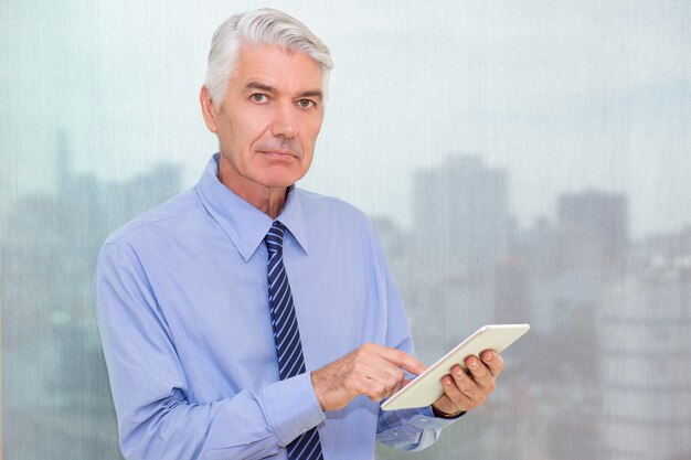 Confident senior businessman with digital tablet