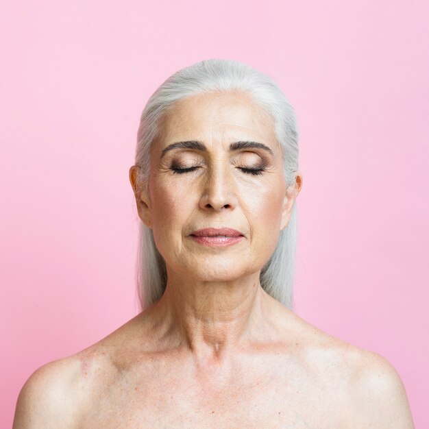 Confident senior woman with pink background