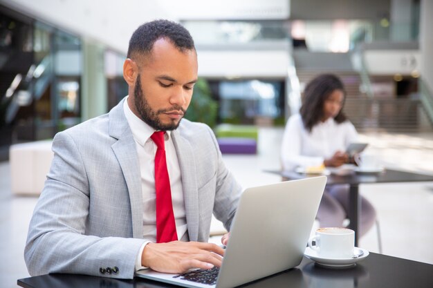 Confident serious executive working during coffee break