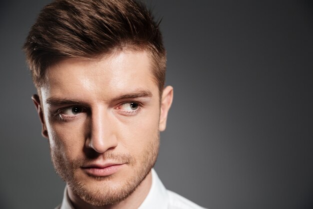 Confident serious man in shirt looking away at copy space