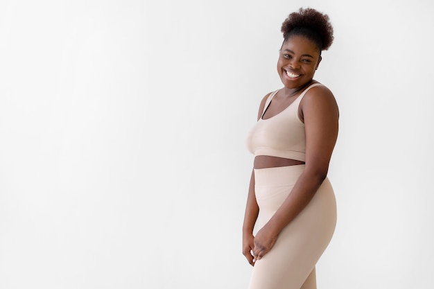 Confident smiley woman posing while wearing a body shaper with copy space