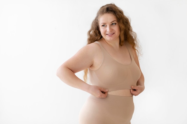 Fiduciosa donna sorridente in posa mentre indossa un body shaper