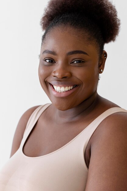 Free photo confident smiley woman posing while wearing a body shaper