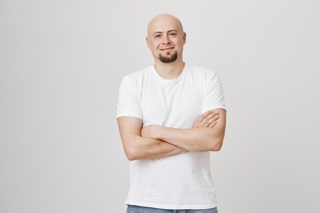 Confident smiling bald bearded man cross arms over chest