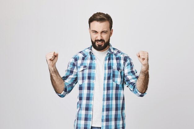 Confident strong middle-aged man clench fists determined win