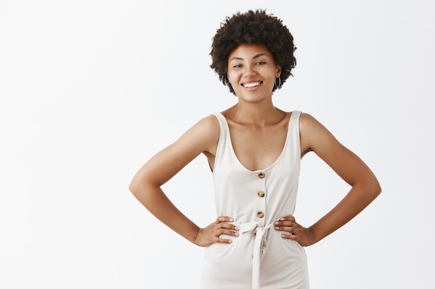 Confident stylish girl posing against the white wall