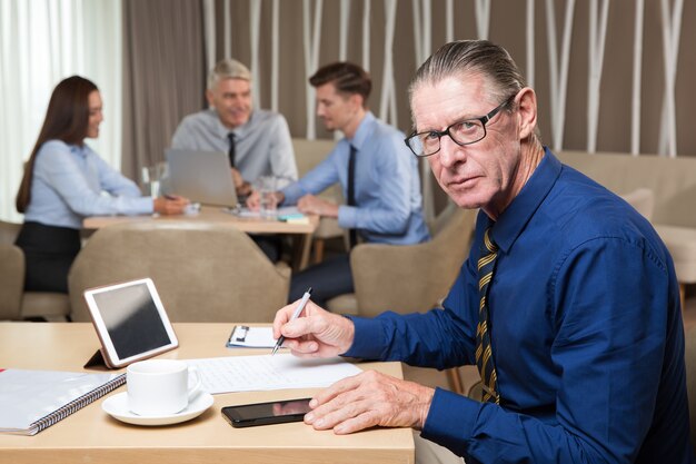 Confident Successful Senior Man Working in Cafe