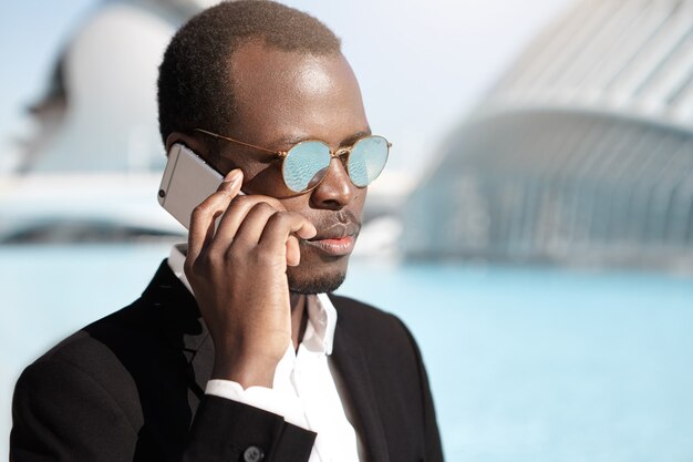 confident successful young entrepreneur having business talk on mobile phone