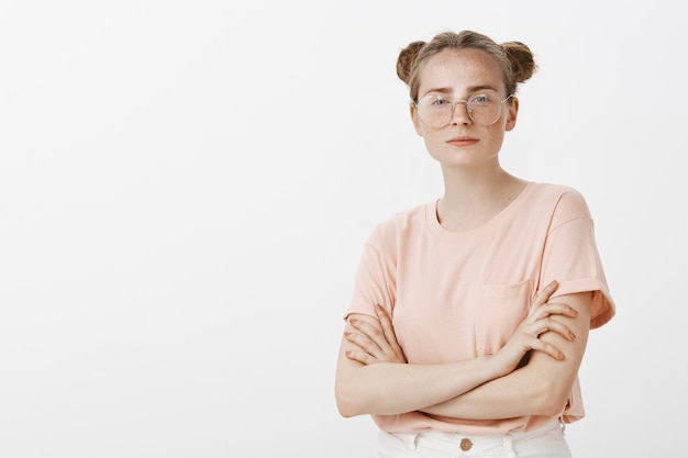 Confident teenage girl posing against the white wall