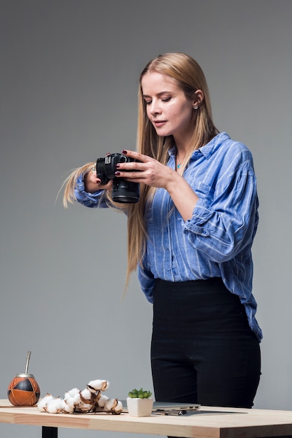 Confident woman in blue shirt taking food pictures