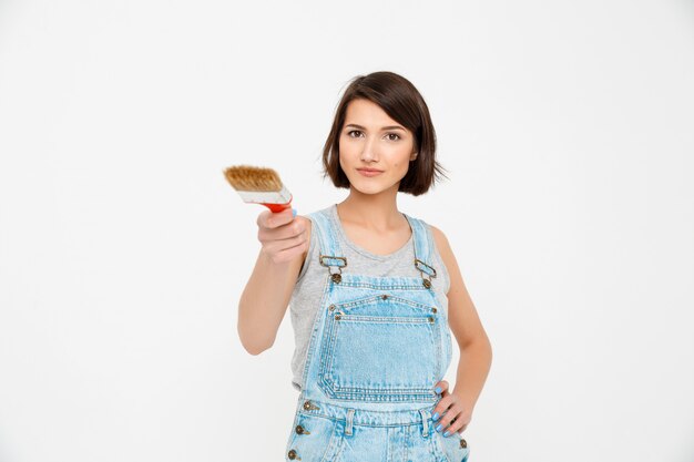 Confident woman builder with painting brush