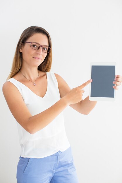 Confident woman in glasses pointing at touchpad