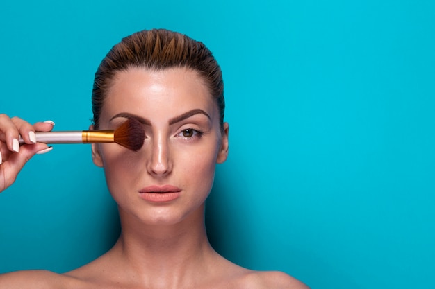 Confident woman holding a make up brush