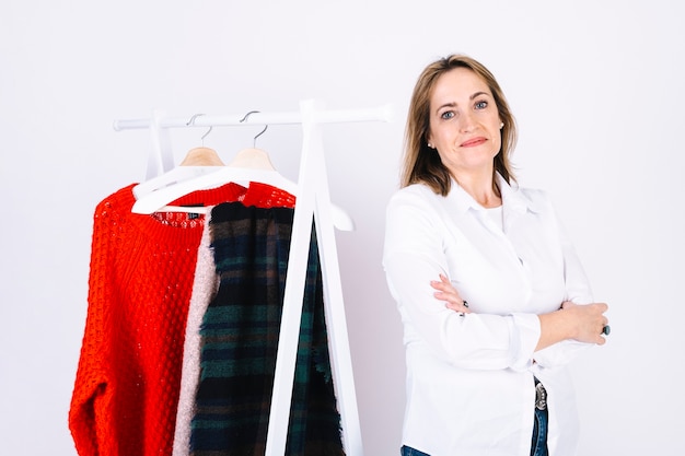 Free photo confident woman near clothes rack