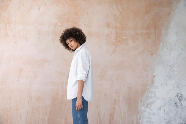 Foto gratuita donna sicura con la posa dei capelli ricci