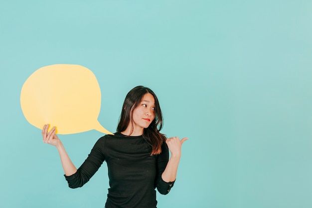 Confident woman with speech bubble pointing right