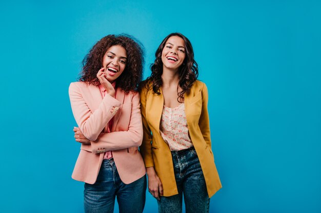 Confident women standing on blue wall