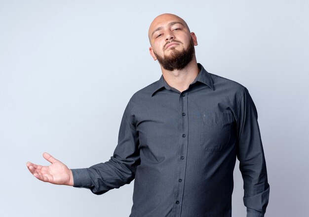 Confident young bald call center man showing empty hand isolated on white 