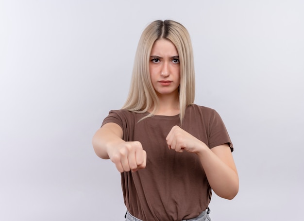 Confident young blonde girl doing boxing gesture  on isolated white space with copy space