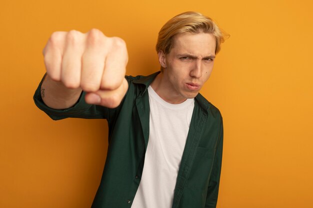 Confident young blonde guy wearing green t-shirt holding out fist