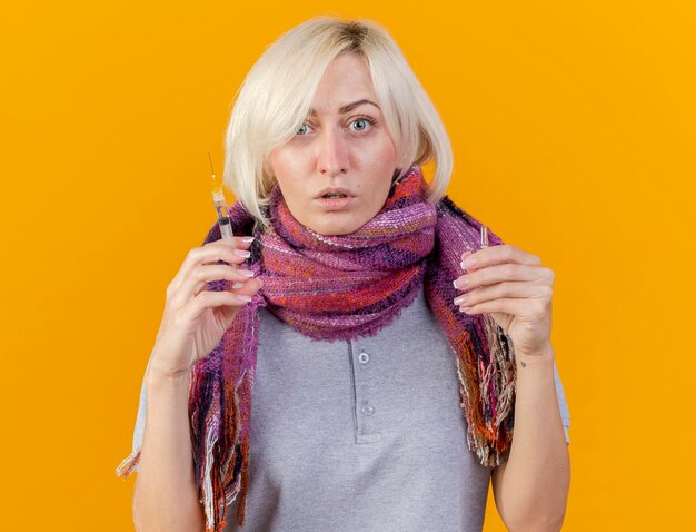 Confident young blonde ill slavic woman wearing scarf holds syringe