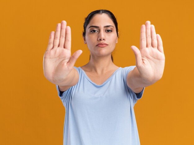 Confident young brunette caucasian girl gesturing stop sign with two hands