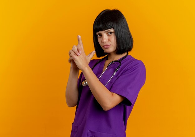 Confident young brunette female doctor in uniform with stethoscope