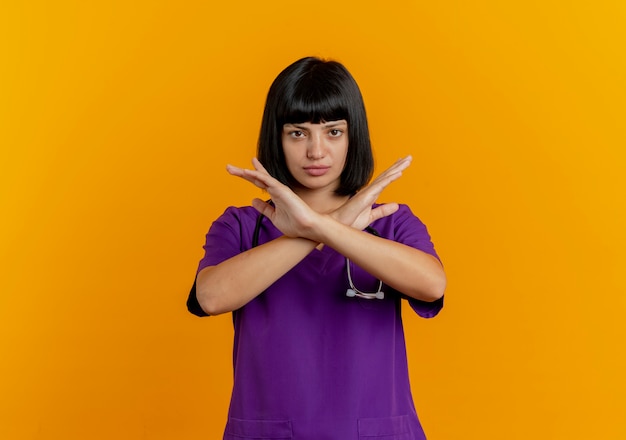 Confident young brunette female doctor in uniform with stethoscope