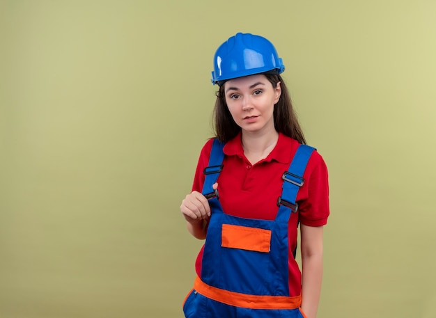 파란색 안전 헬멧 자신감 젊은 작성기 소녀 복사 공간이 격리 된 녹색 배경에 유니폼에 보유
