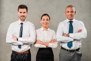 Free photo confident young businessmen and businesswoman with their arms crossed looking to camera